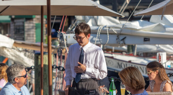 Waiter speaking with customers outside