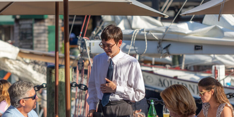 Waiter speaking with customers outside